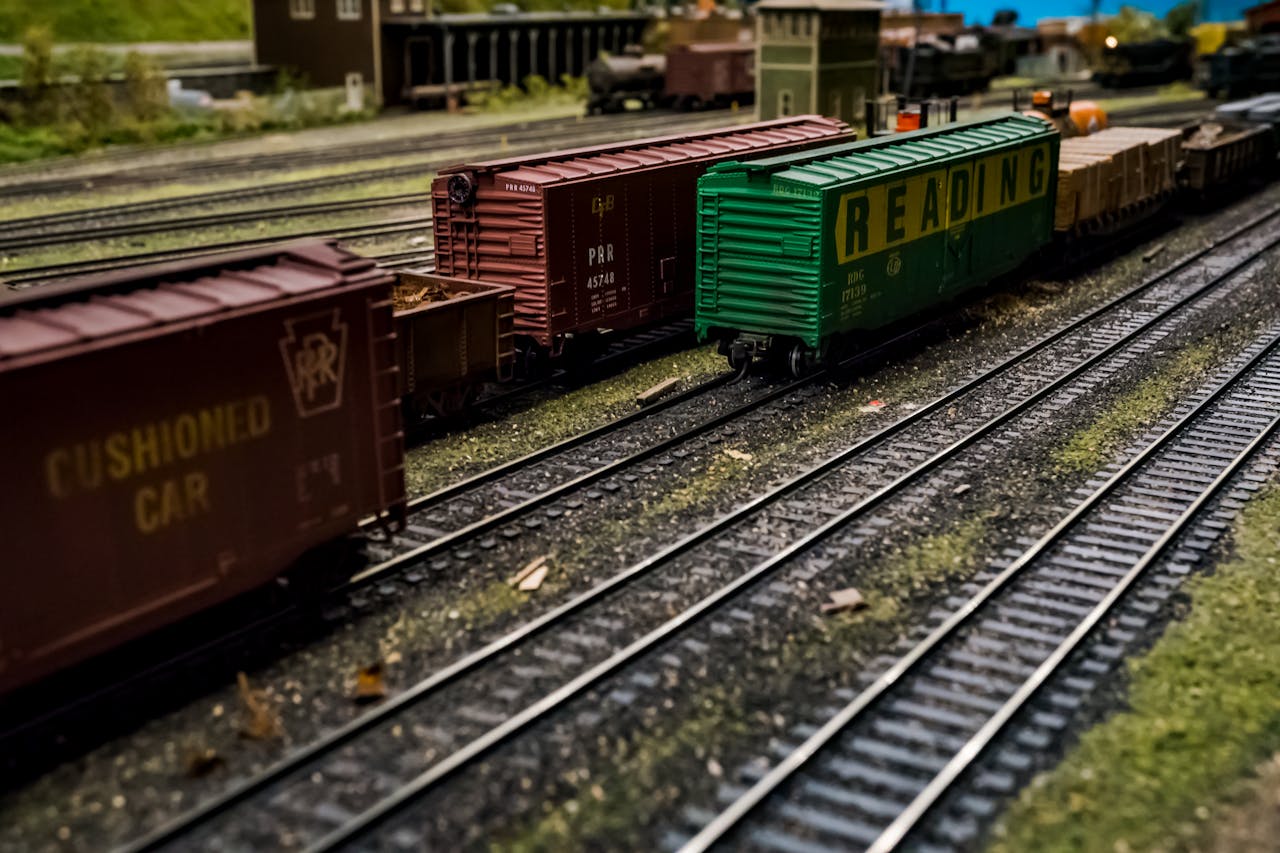 Close-up of a model train on a detailed miniature railway set with tracks and wagons.